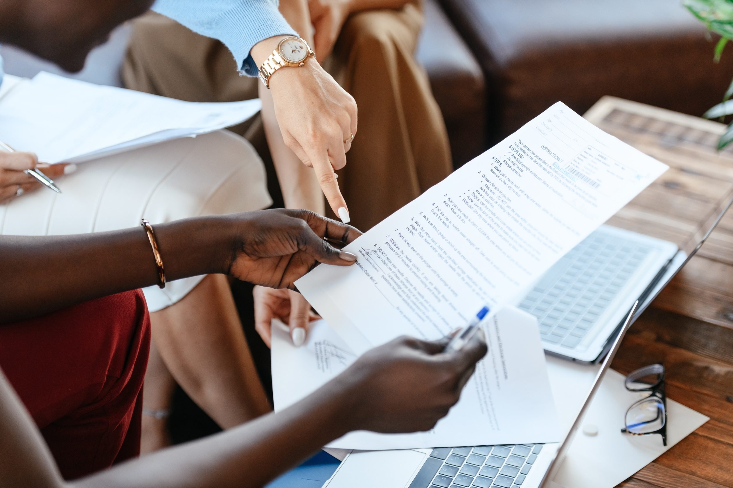 Person holding a document with another person pointing to something on the document 